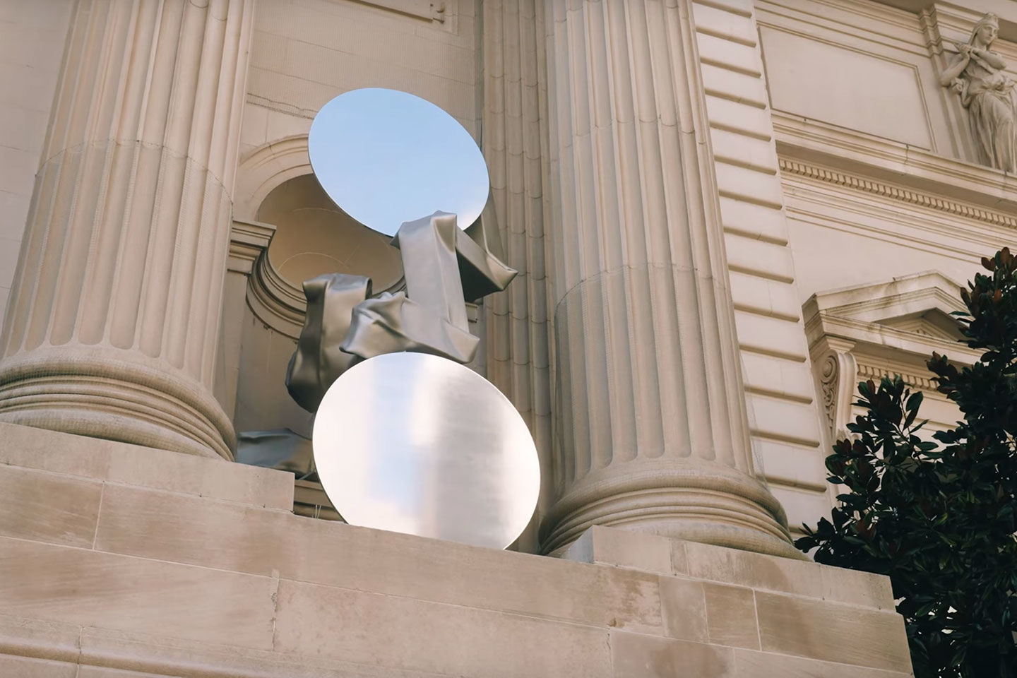 A reflective sphere shimmers against the granite facade of the Metropolitan Museum of Art